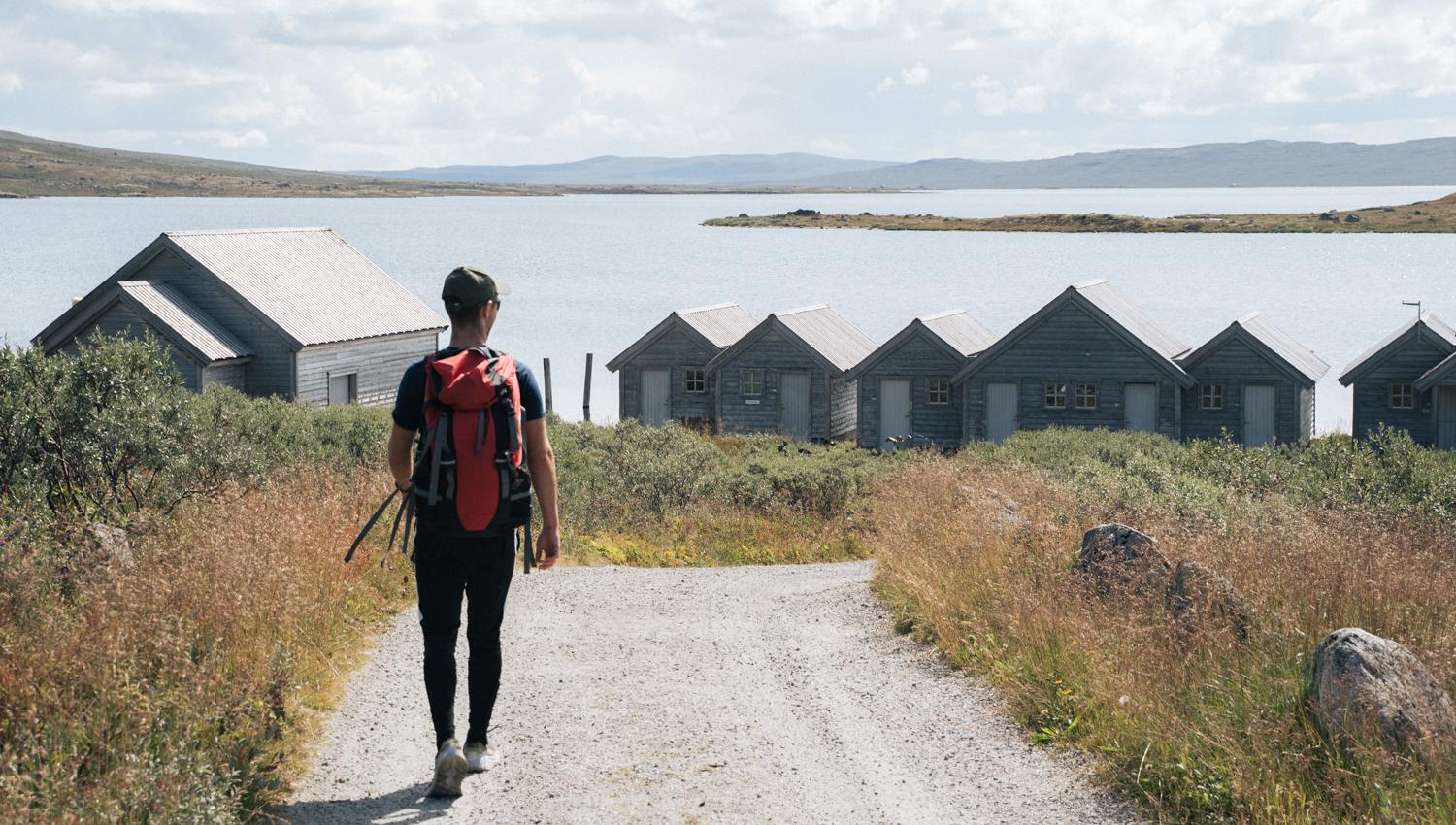 A man walking downhill towards the harbour area at Halne.
