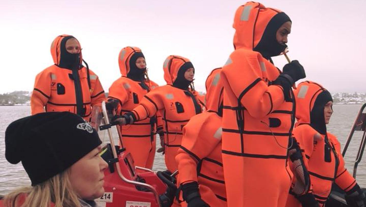 People in orange suits on a boat