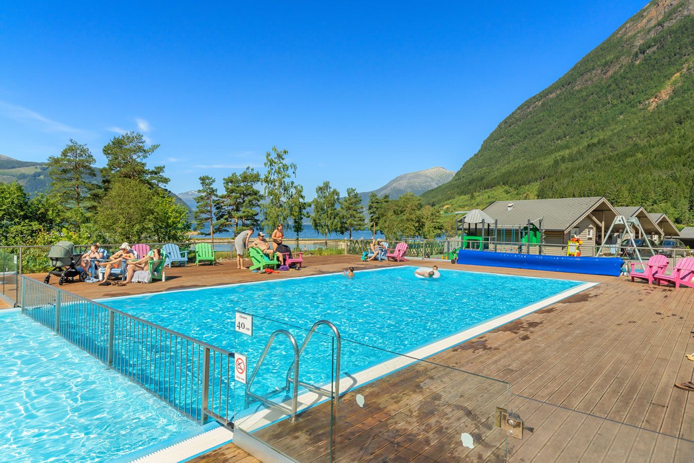 Beheizter Außenpool im Mikkelparken Ferietun mit spektakulärem Blick auf den Hardangerfjord und grüne Berghänge.