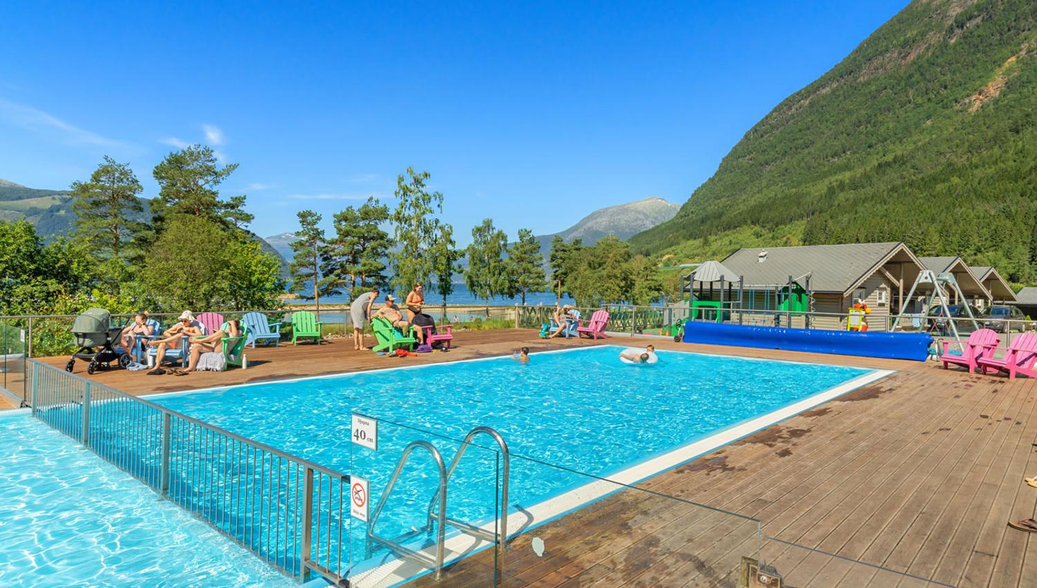 Beheizter Außenpool im Mikkelparken Ferietun mit spektakulärem Blick auf den Hardangerfjord und grüne Berghänge.