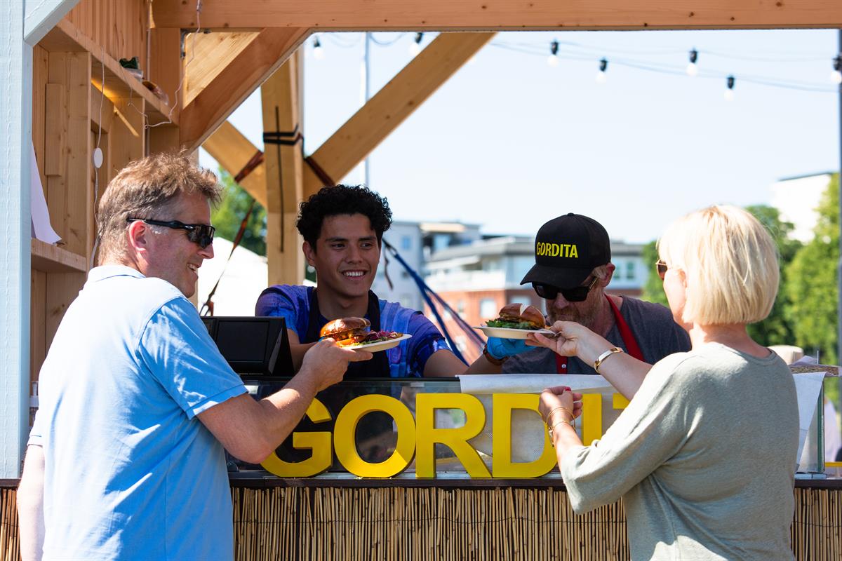Gruppe gjester ved en strandbar som får servert drikke.