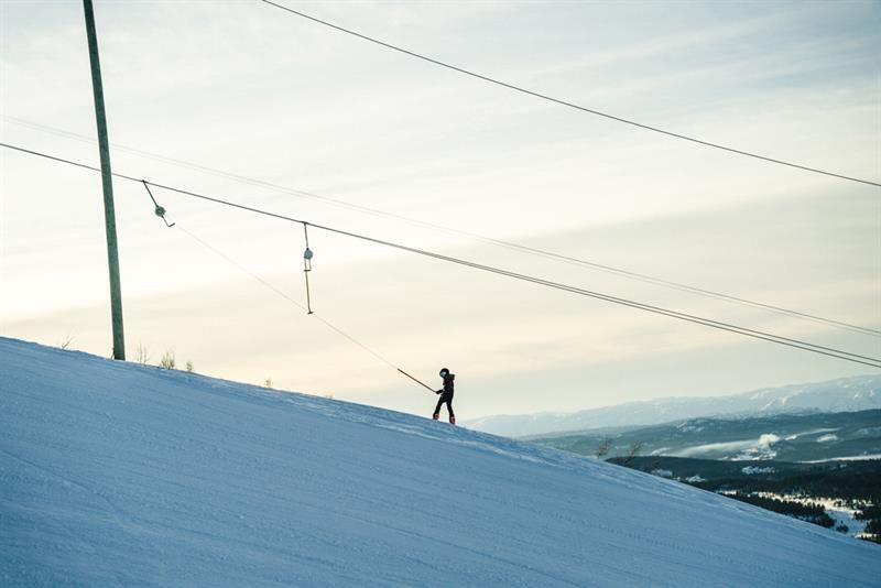 skier uses ski lift up the hill 