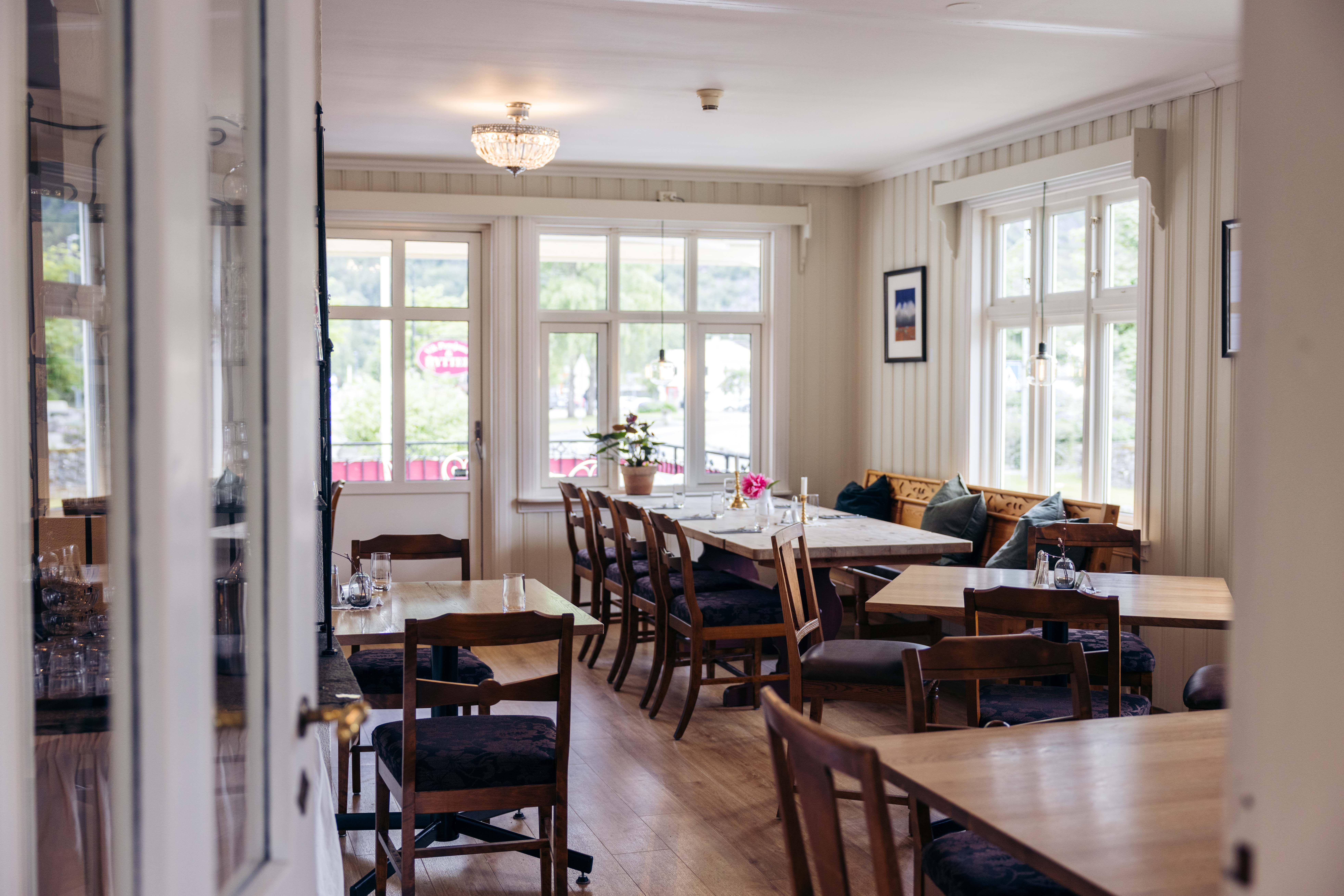 A photo of the restaurant, showing several dining tables and chairs.