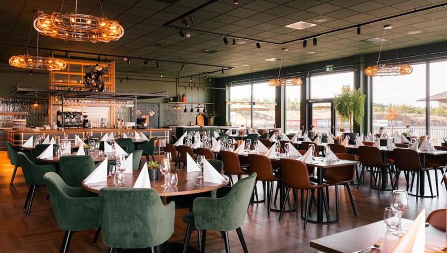 Restaurant, dekket bord og utsikt til motorbane