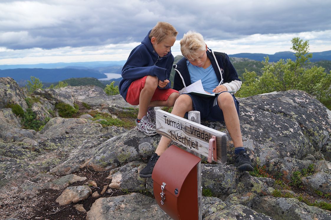 2 boys look at a map on a hike to Venelifjell in Vrådal 