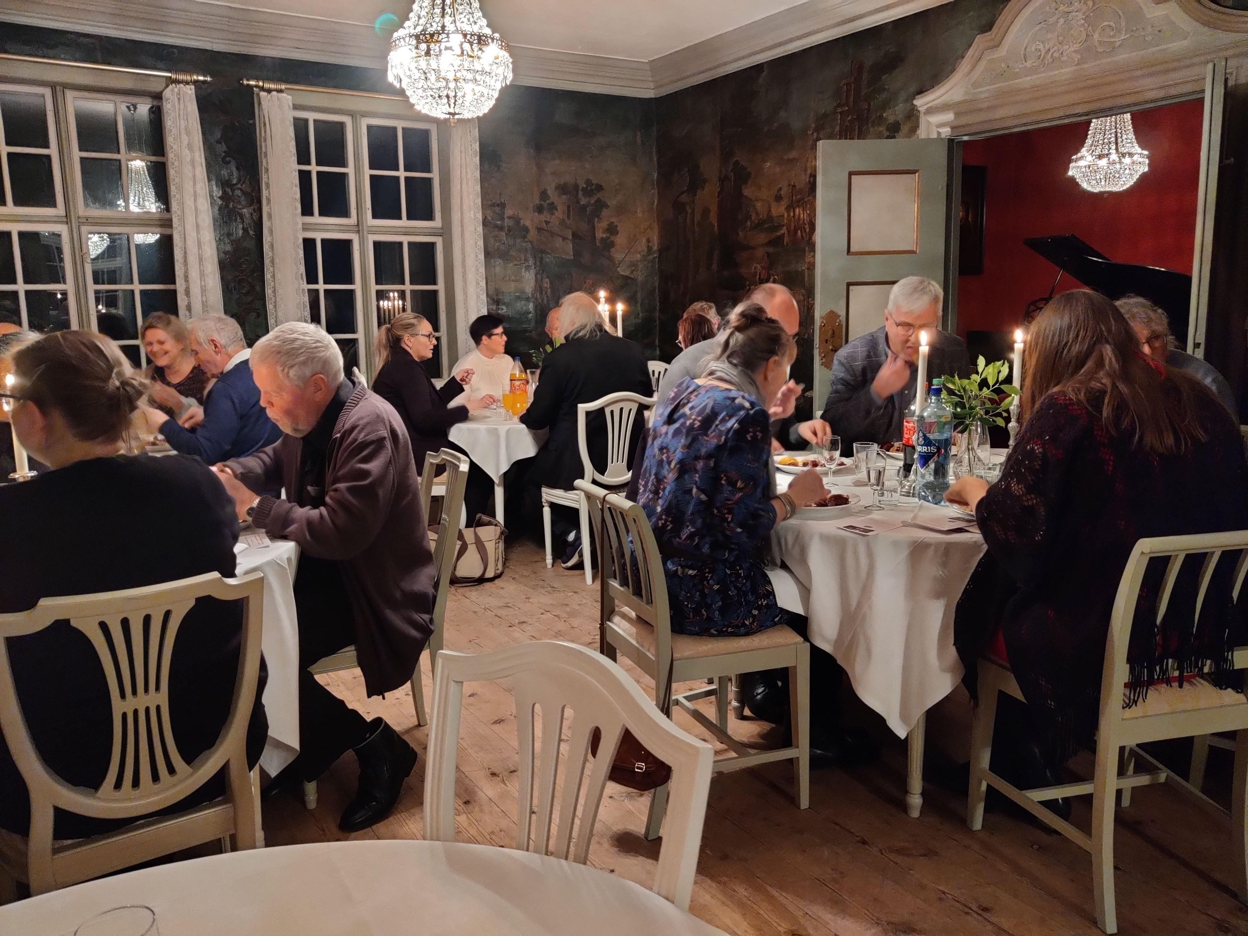 Guests gathered for dinner in the historic festive hall at Skrivergaarden, surrounded by classic interiors and historic details.