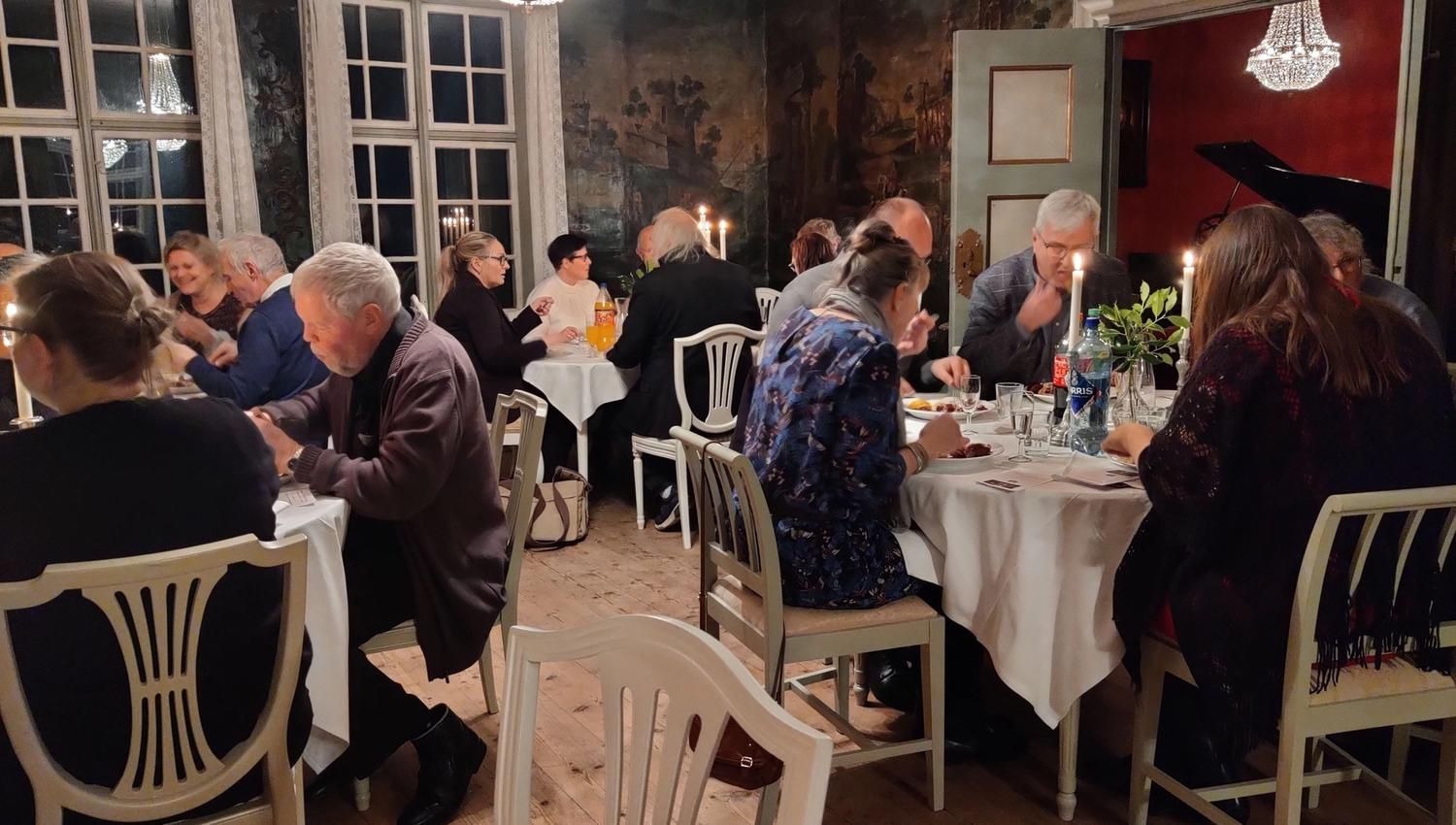 Guests gathered for dinner in the historic festive hall at Skrivergaarden, surrounded by classic interiors and historic details.