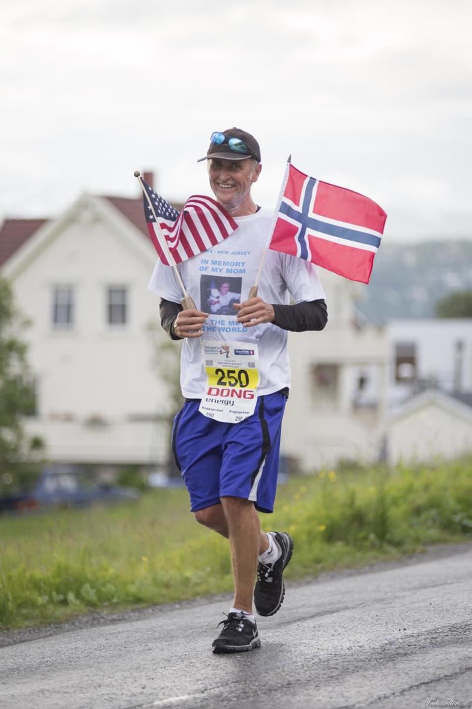 A contestant runs holding the Norwegian and American flag