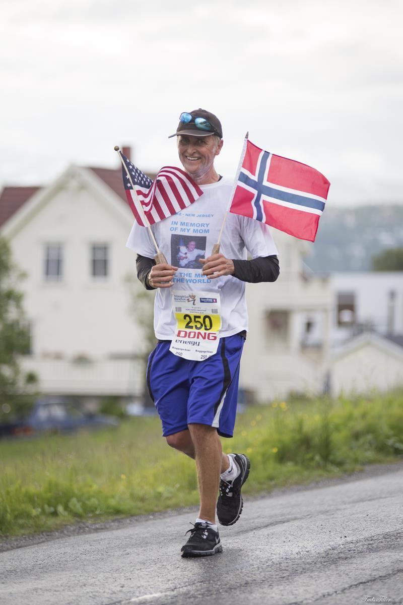 A contestant runs holding the Norwegian and American flag