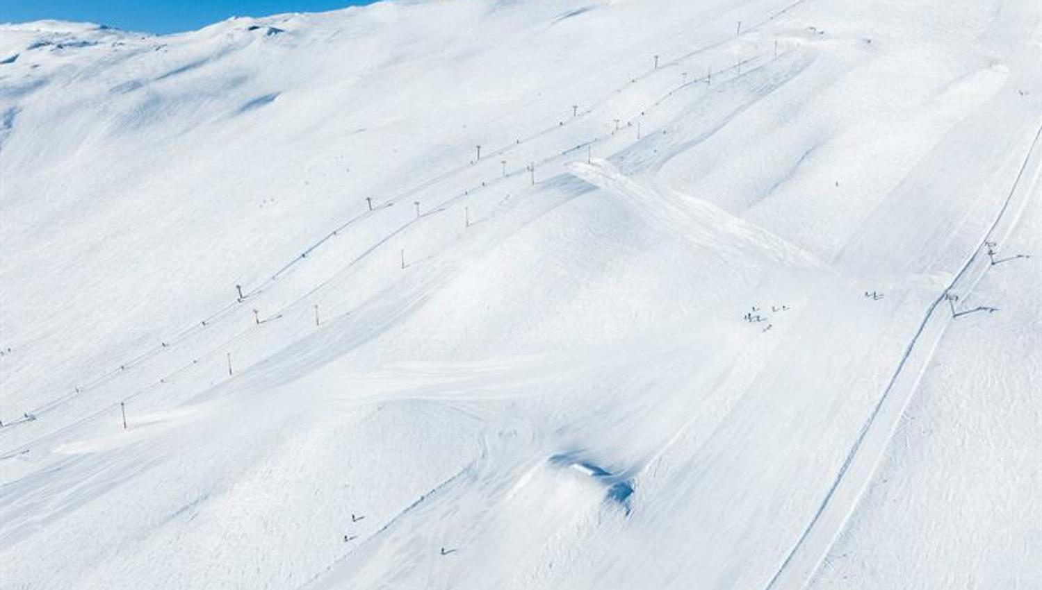 Sonnige Pisten und Skilifte im Røldal Skigebiet, umgeben von schneebedeckten Gipfeln.