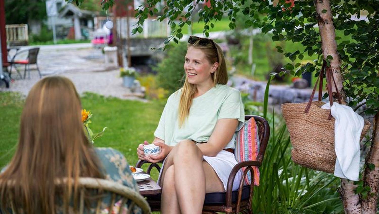 2 damer sitter i hagen til Garveriet i Viosen