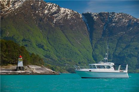 Pilagutt anchored in the Hardangerfjord, surrounded by majestic mountains and turquoise water. The ultimate fjord experience.