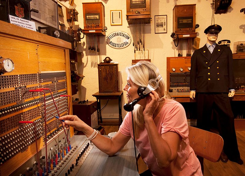 dame som sitter i en gammel telefonsentrale som utstilles på Z-museum i Nissedal