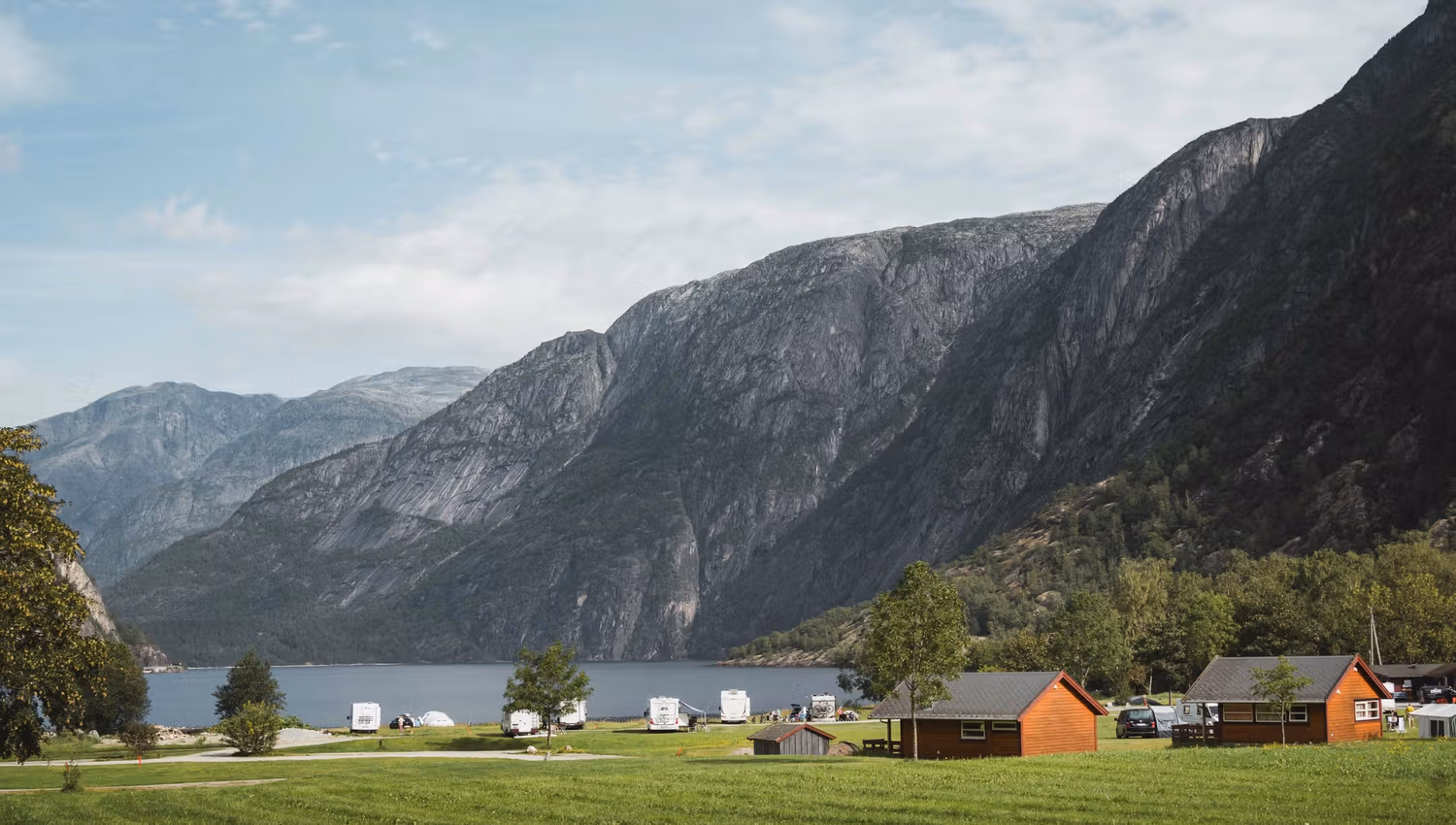 Sæbø camping seen from the main road, with the lake and mountains in the background.