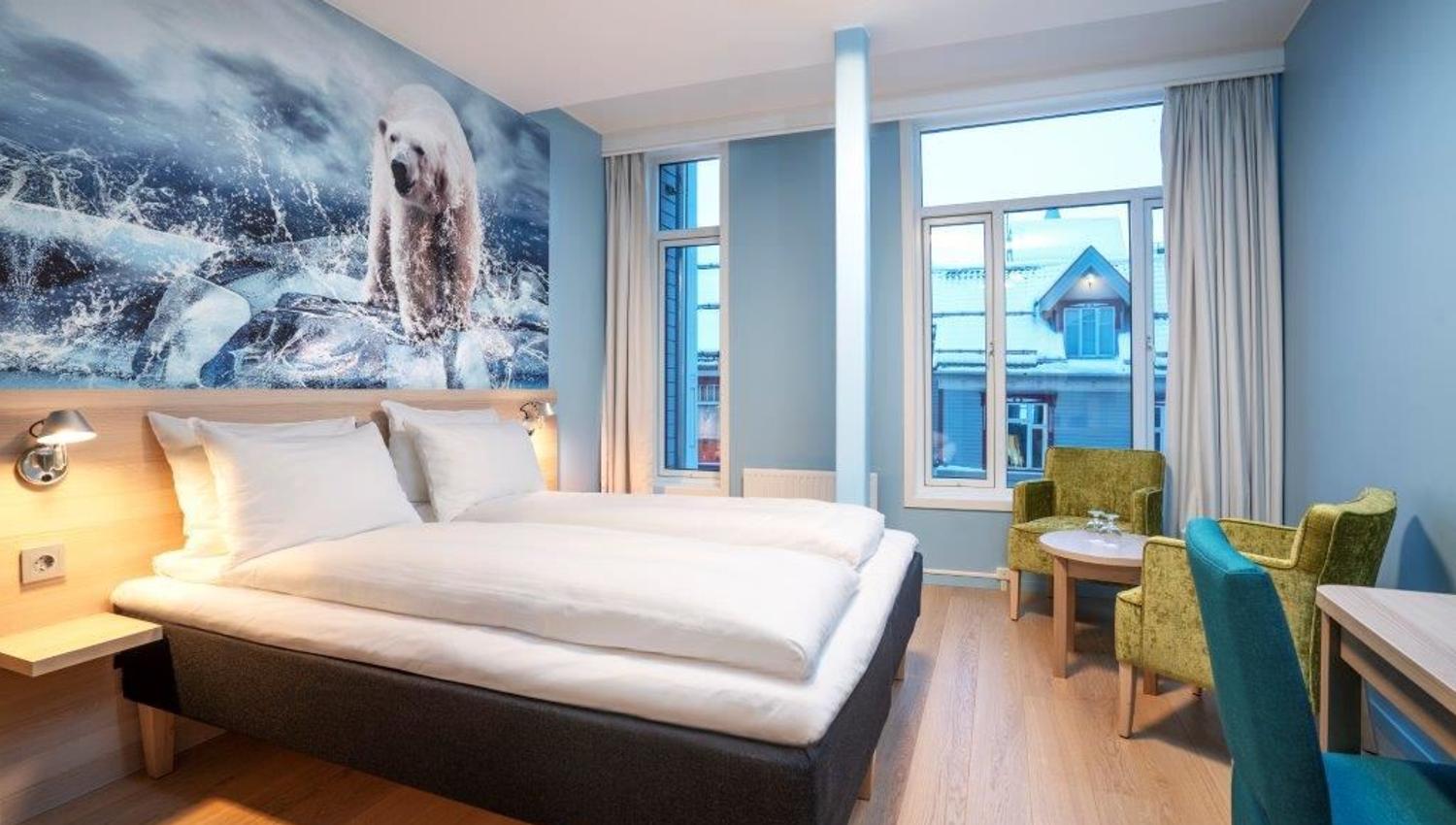 Modern room with a large bed, polar bear mural on the wall, and seating area.