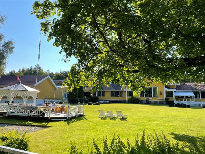 Hankø Hotell & Spa med stor grønn hage, solsenger og utendørs terrasse omgitt av trær.
