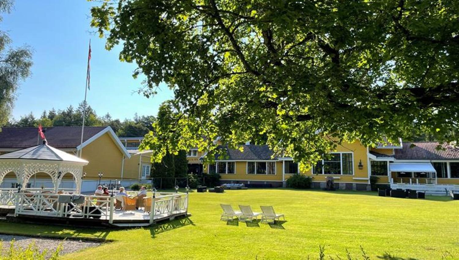 Hankø Hotell & Spa med stor grønn hage, solsenger og utendørs terrasse omgitt av trær.