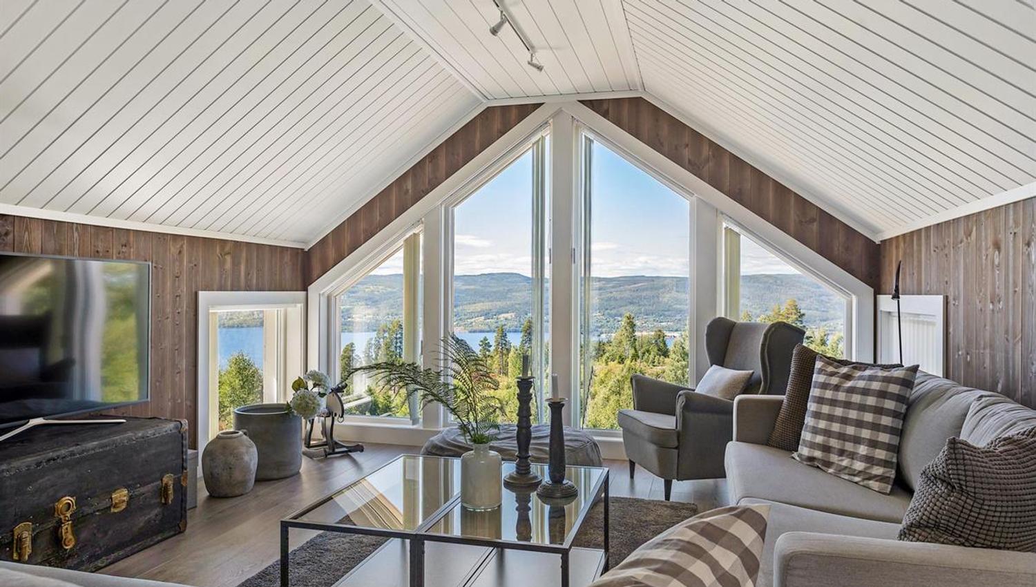 A bright living room with large windows overlooking the landscape.