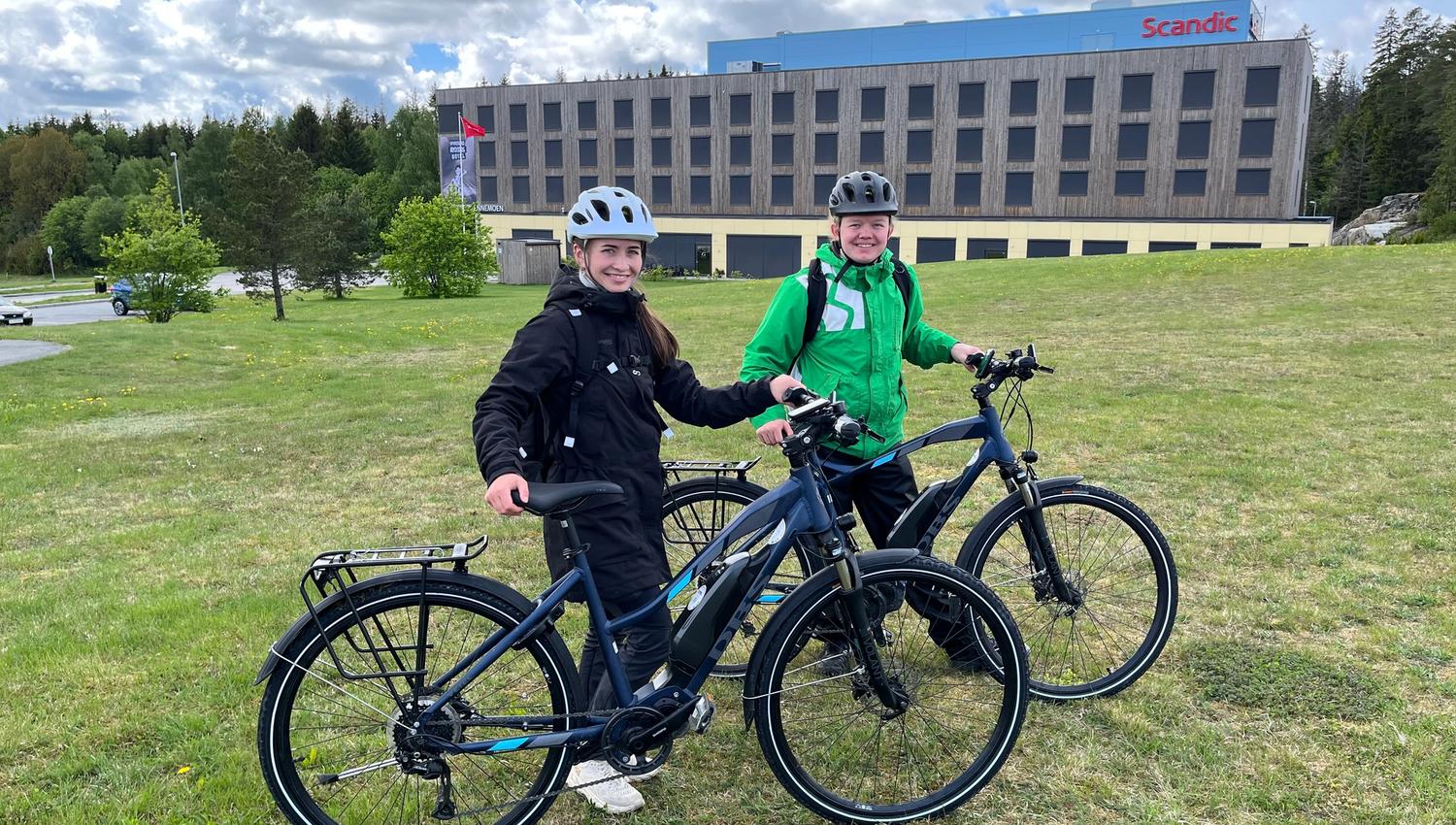 To syklister står på gressplen