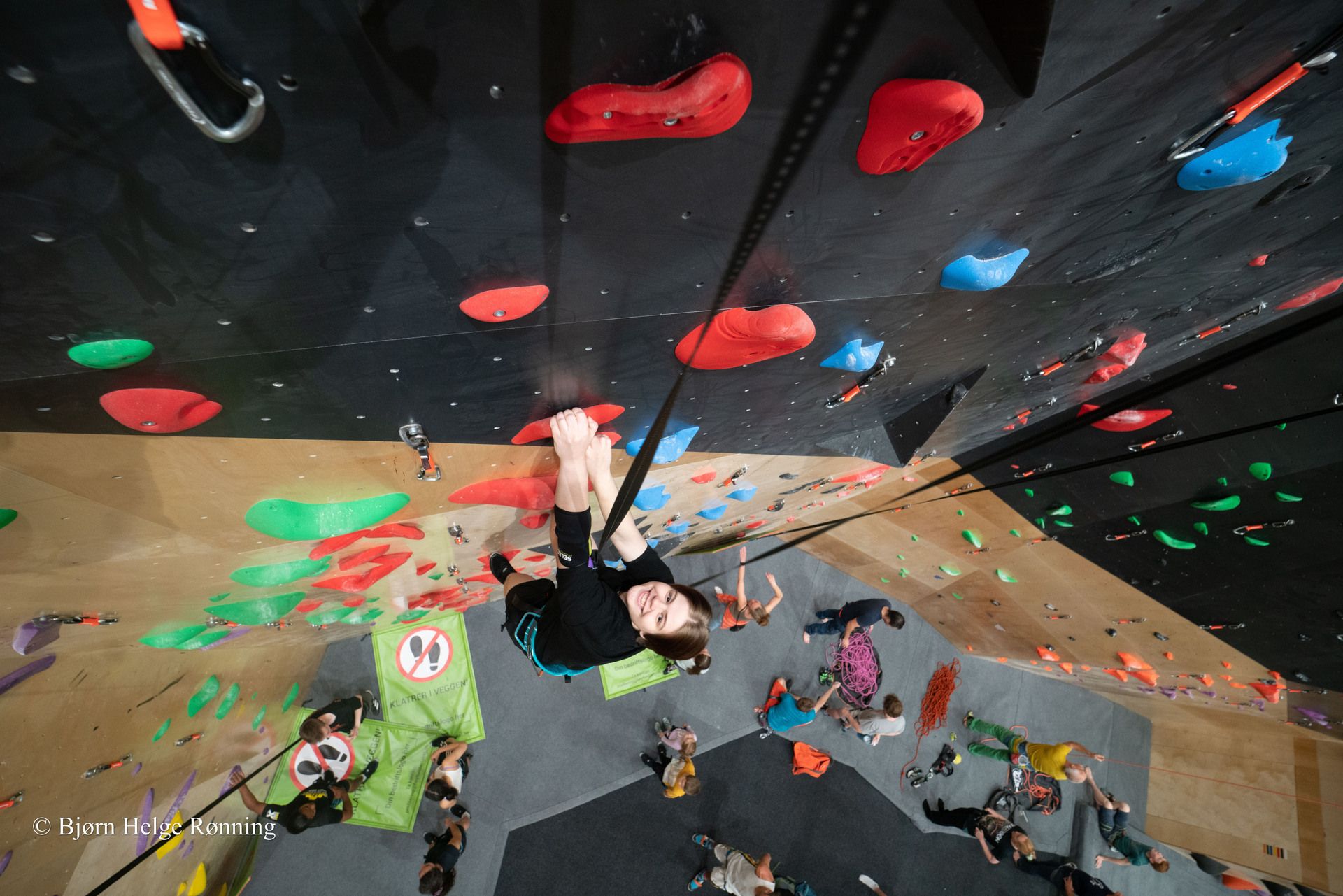 people climbing in an indoor climbing wall