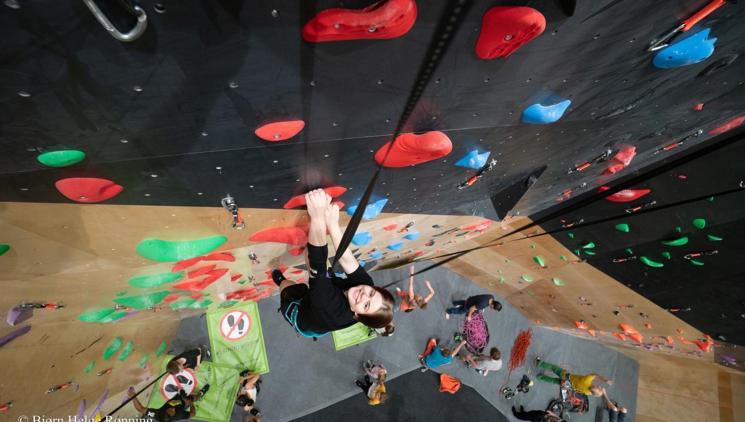people climbing in an indoor climbing wall