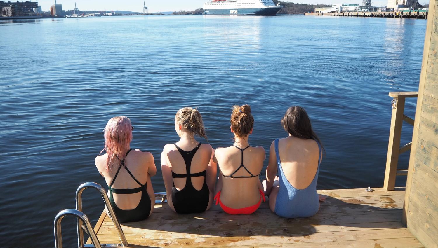 Four girls sitting by the sauna.