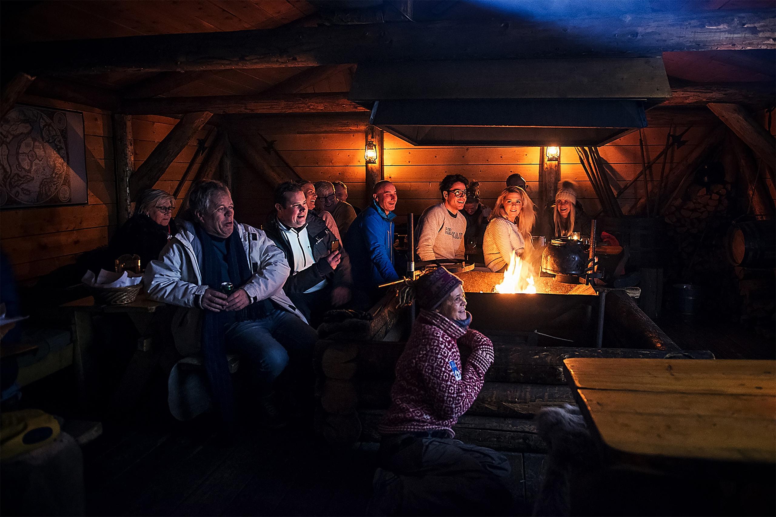 Gjester som følger med på et foredrag inne i hytta på Camp Barentz