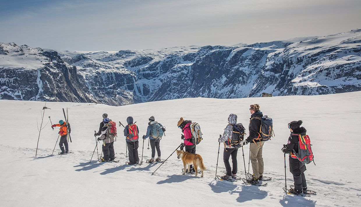 Group of snowshoe hikers crossing a snowy plateau on the way to Trolltunga.
