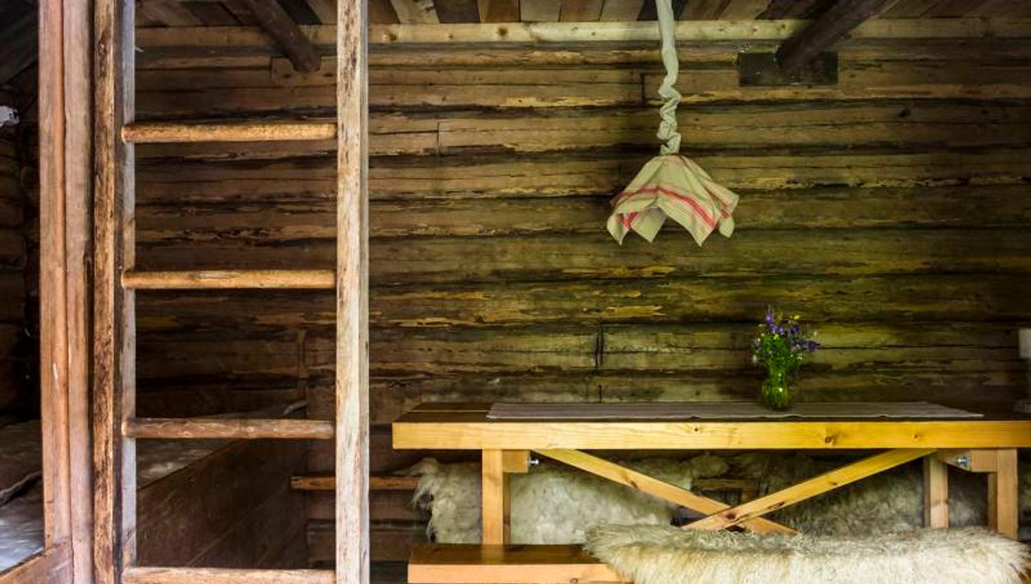 the inside of an old farmershouse with a bench and loft