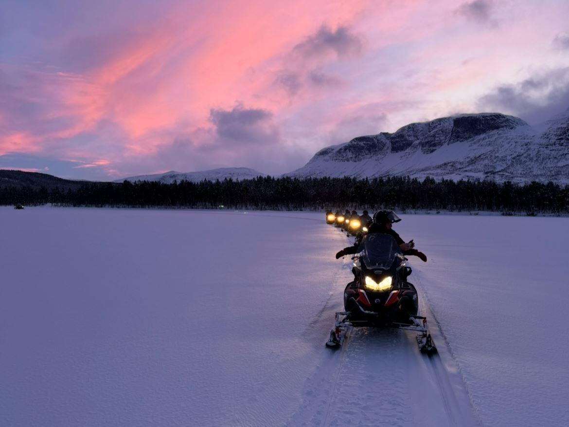 Snowmobile tour through the winter landscape of Skibotn Valley in the evening light