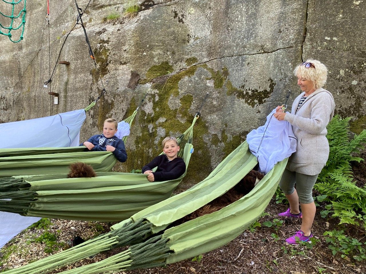 A mother with two children gets ready to sleep in hammocks