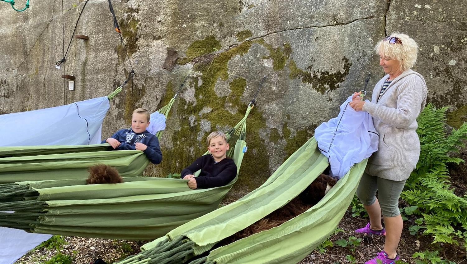 A mother with two children gets ready to sleep in hammocks