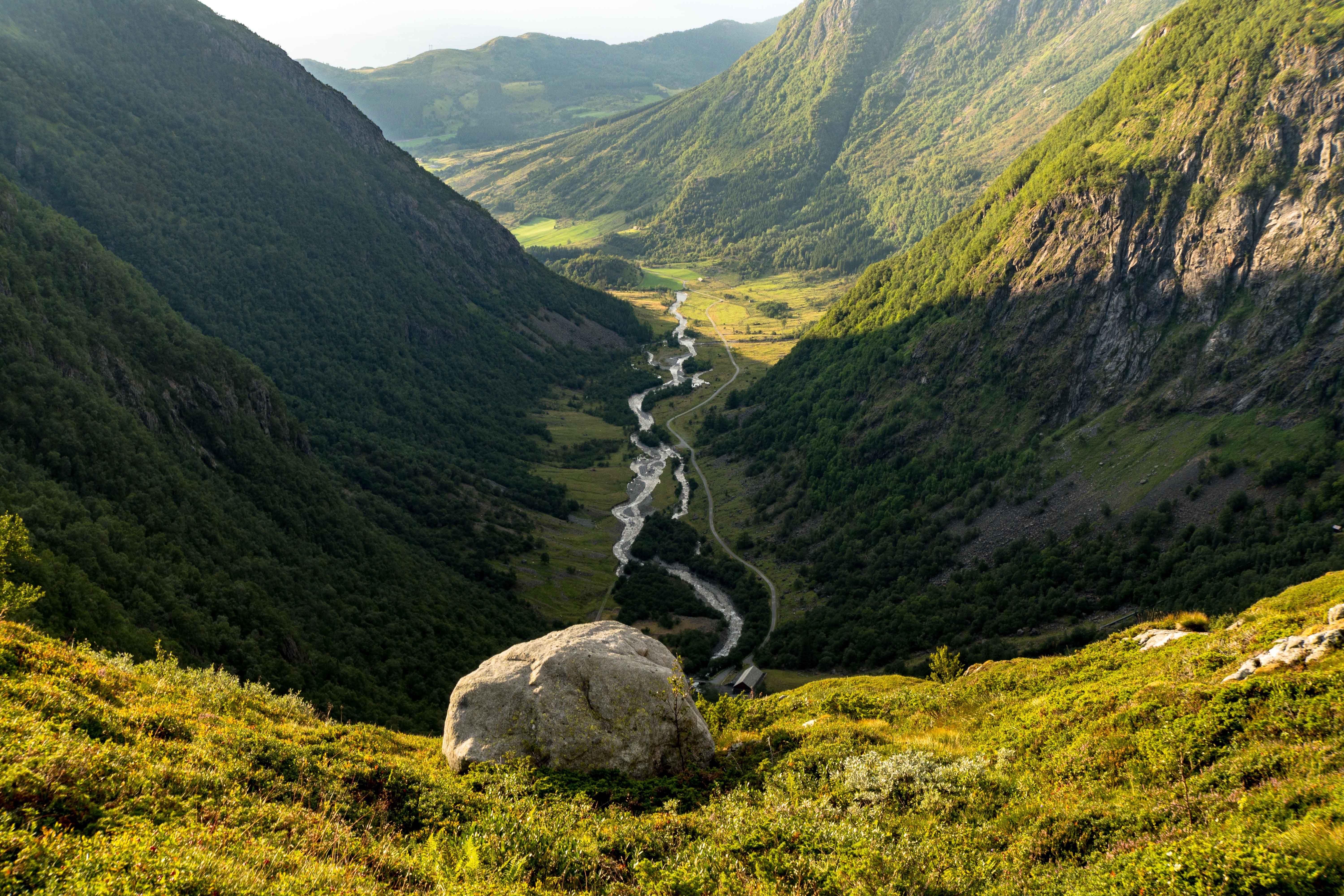 Utsyn ned i Hattebergsdalen der elva slyngjer seg mellom bratte fjellsider og grøne fjellbeiter.