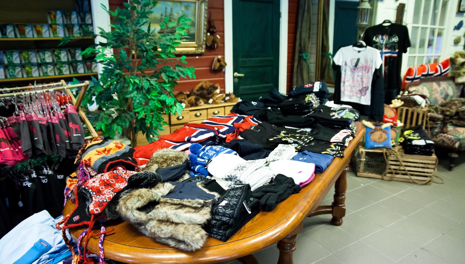 Table filled with gloves, mittens, hats, headbands — typical Norwegian clothing items available for purchase.