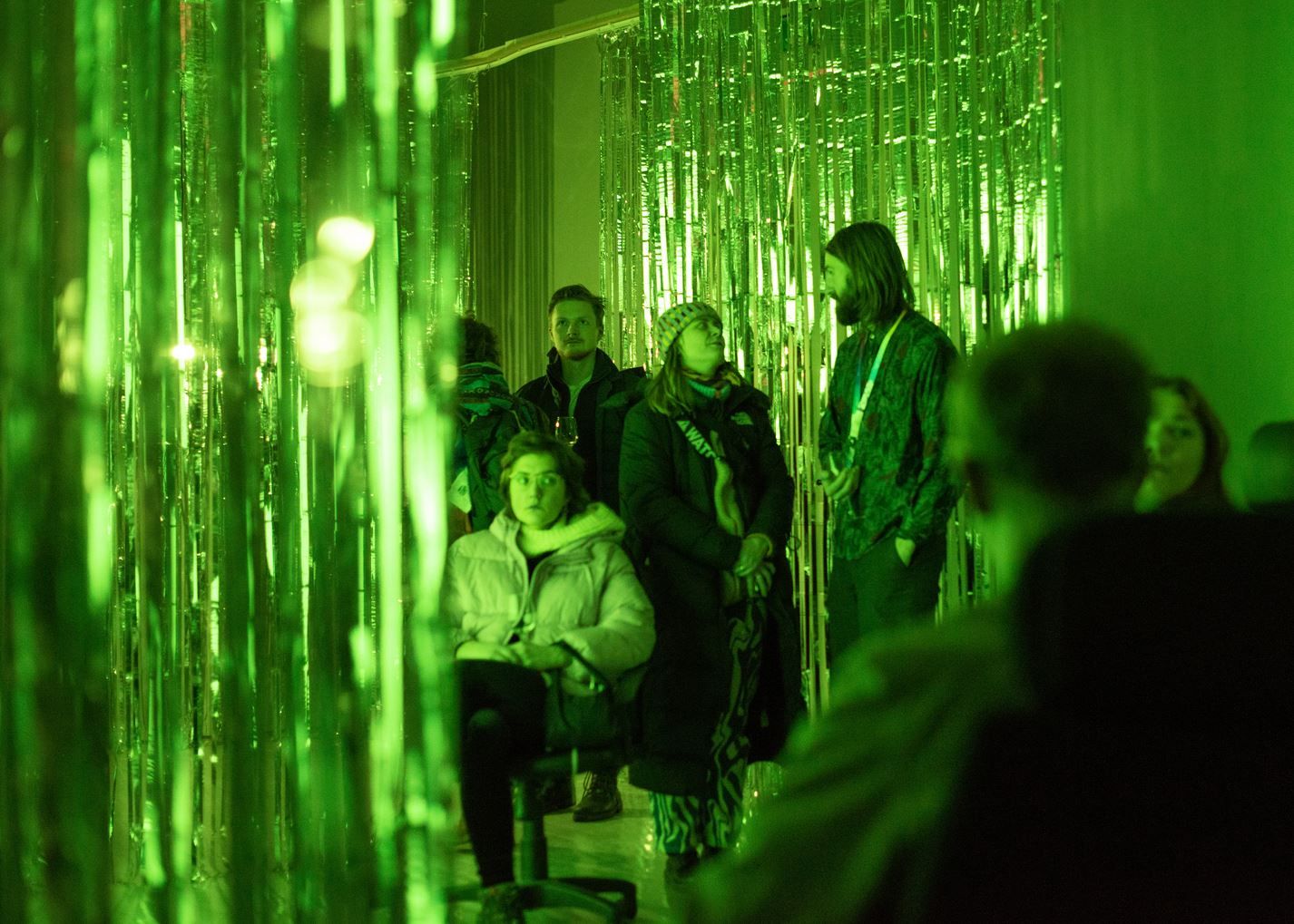 Guests in a green room looking at the exhibition