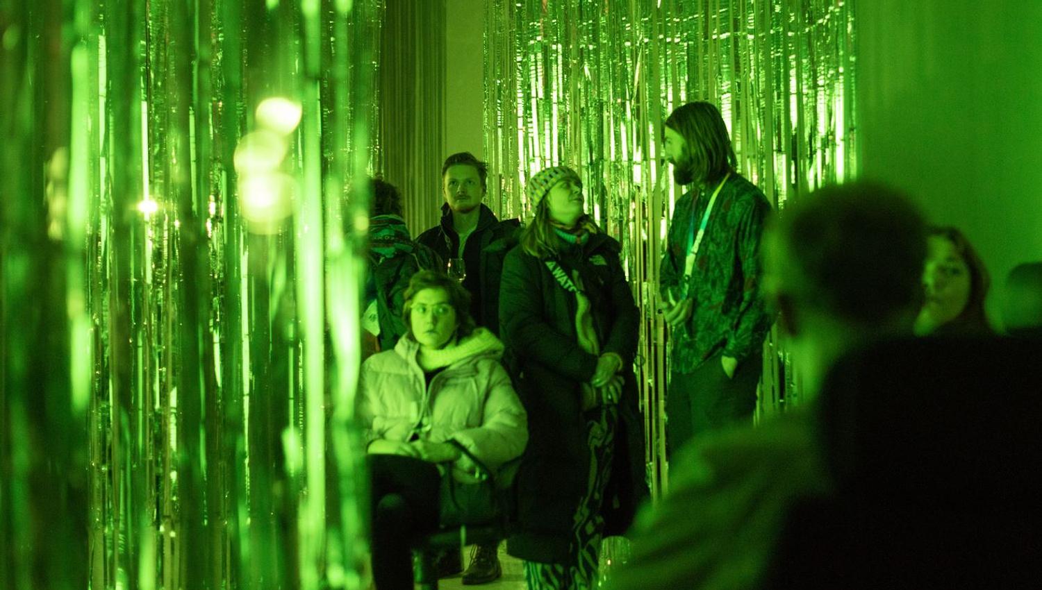 Guests in a green room looking at the exhibition
