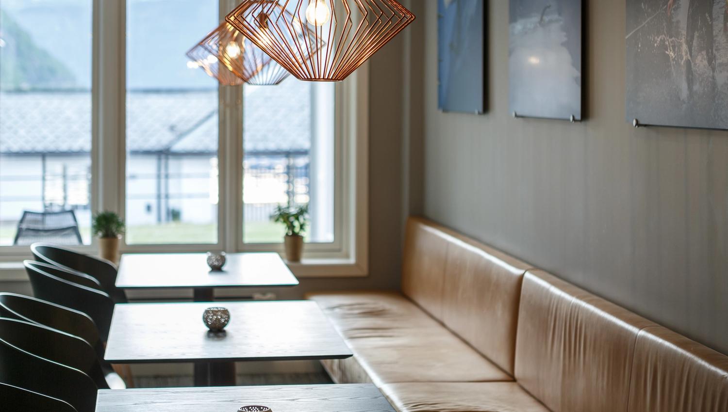 Booths, chairs and tables in the bar area, with a view towards the harbour.