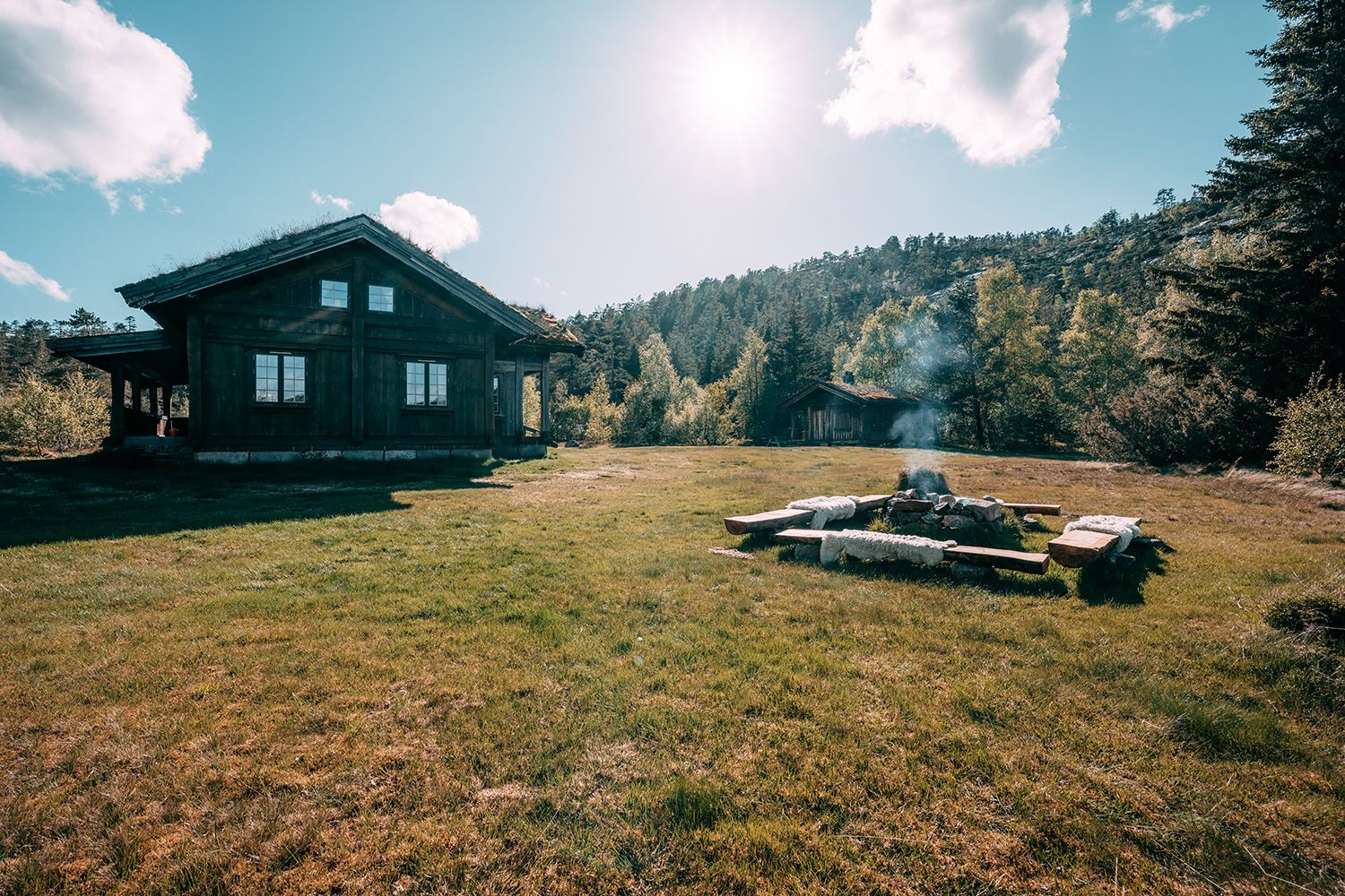 Bålplass utenfor hytteområdet idyllisk ved vannet.