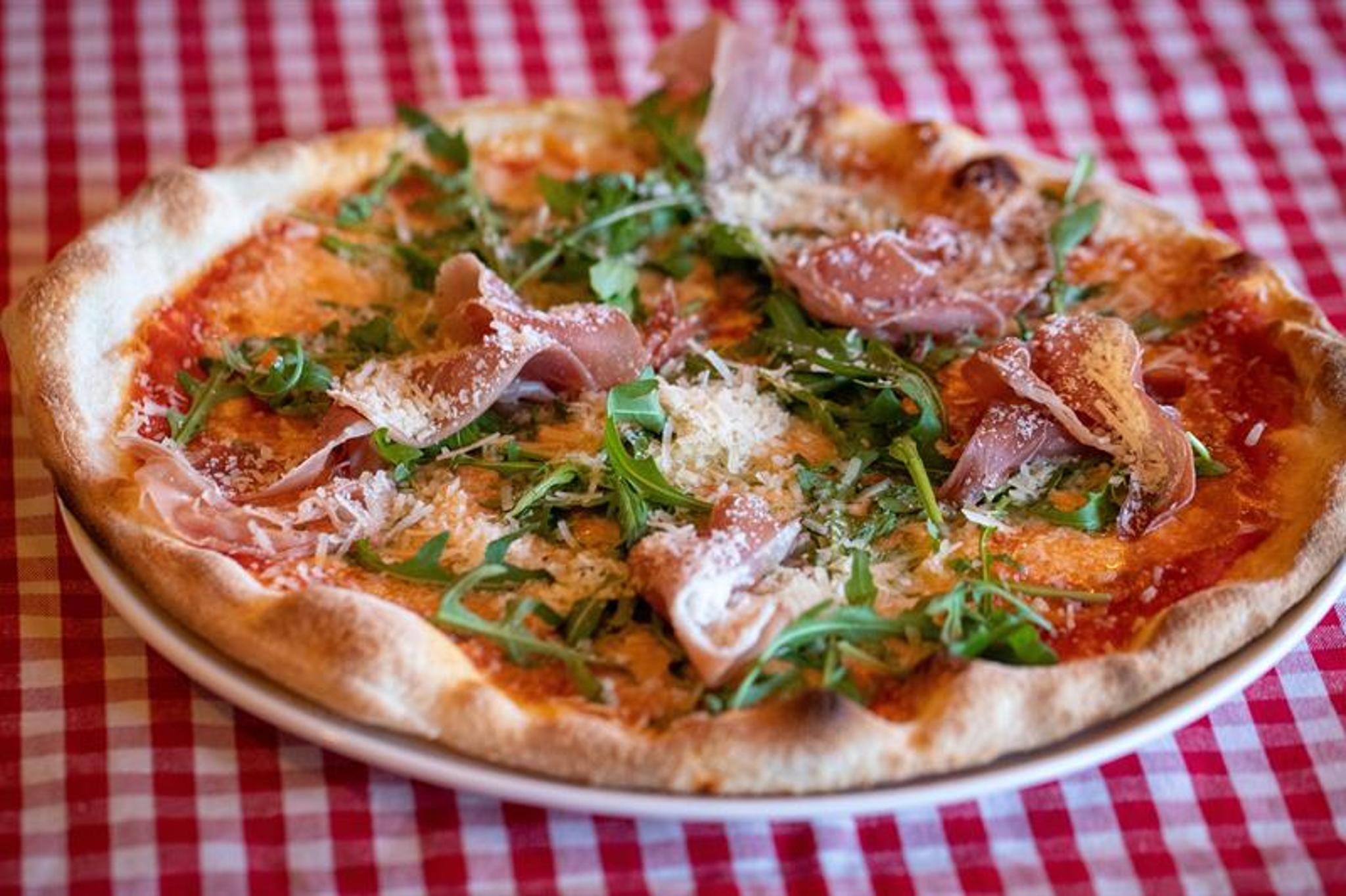 Detalj av pizza på rødrutete duk.