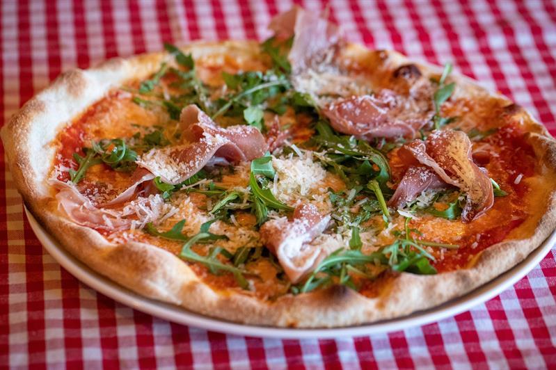 Detalj av pizza på rødrutete duk.