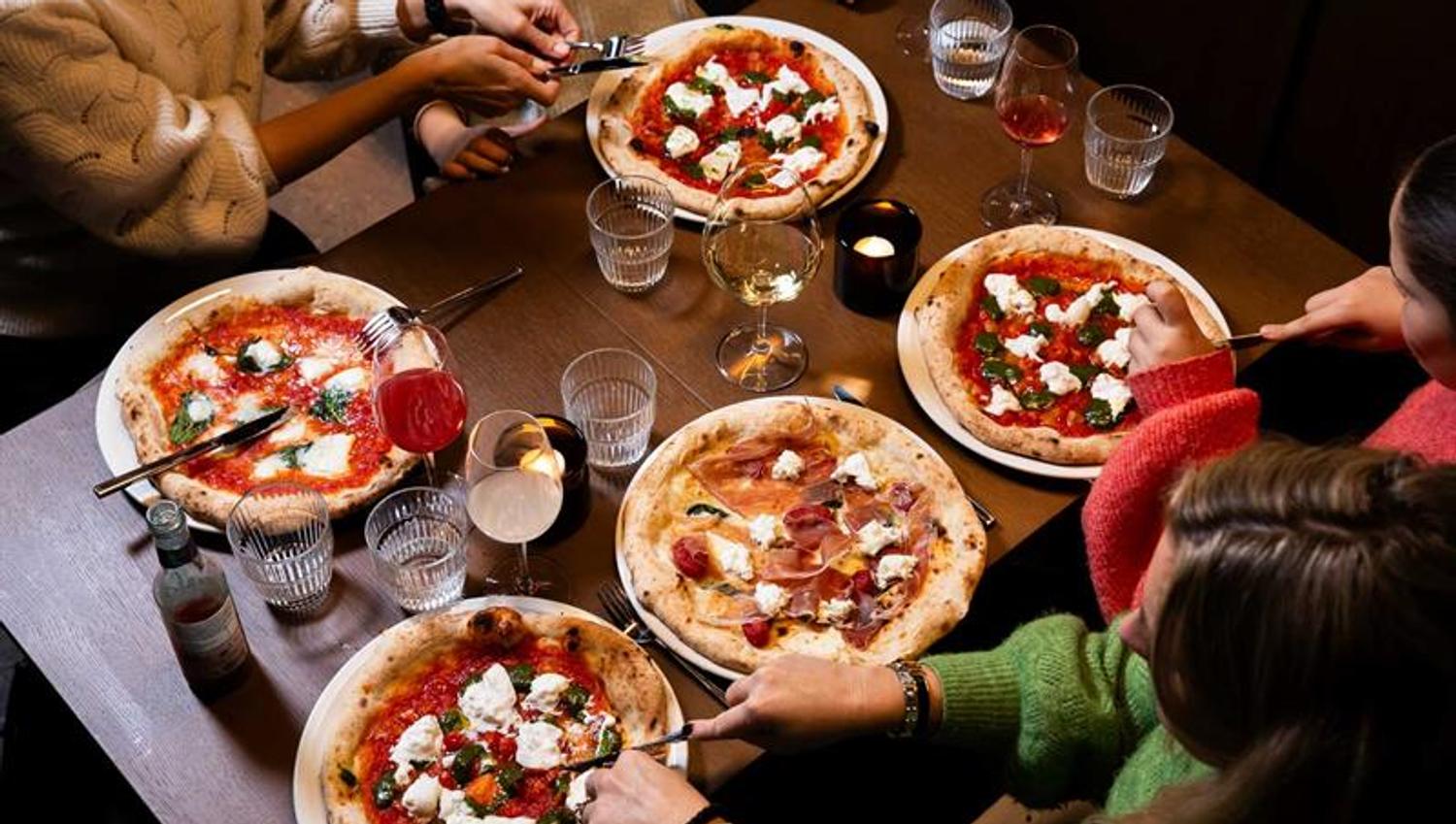 Four people eating pizza