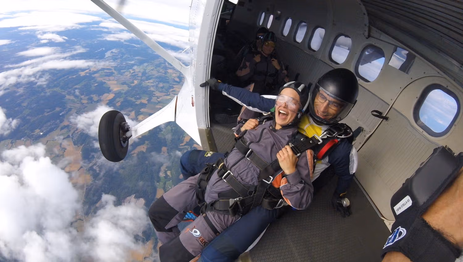 Two people about to jump out of the plane in the air