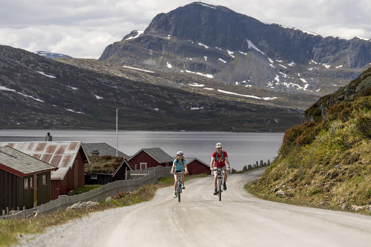 Cycling along Jotunheimvegen, a part of the Mjølkevegen Cycling Route, with the mountain of Bitihorn in the background.