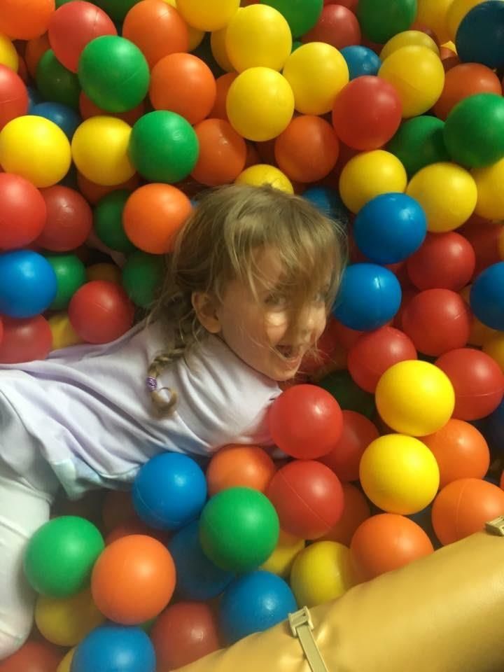 Little girl playing in ball pit
