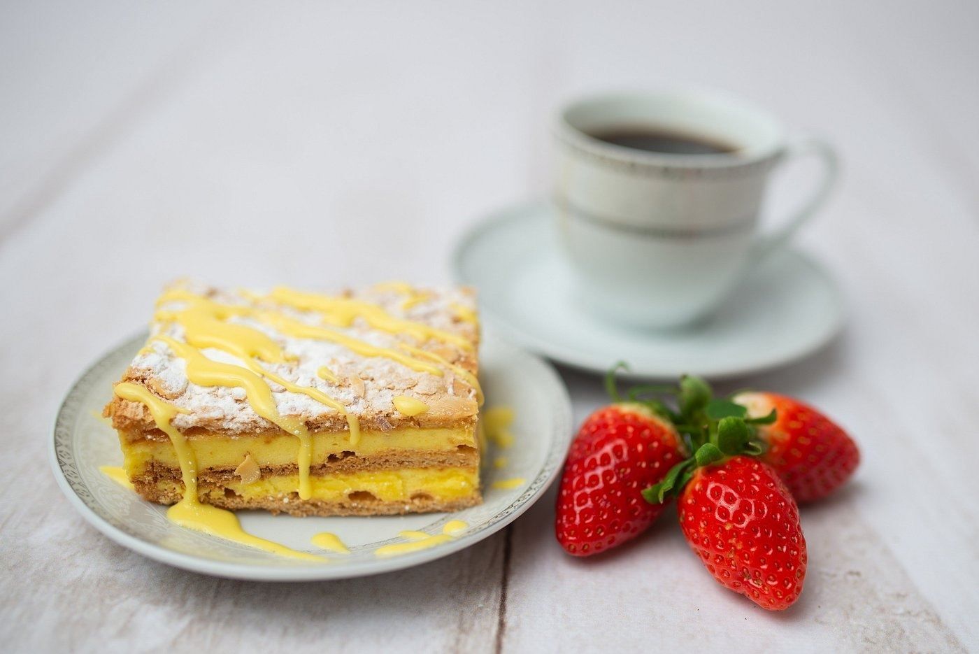 A slice of cake with strawberries and coffee served at Koseverden in Tromsø.