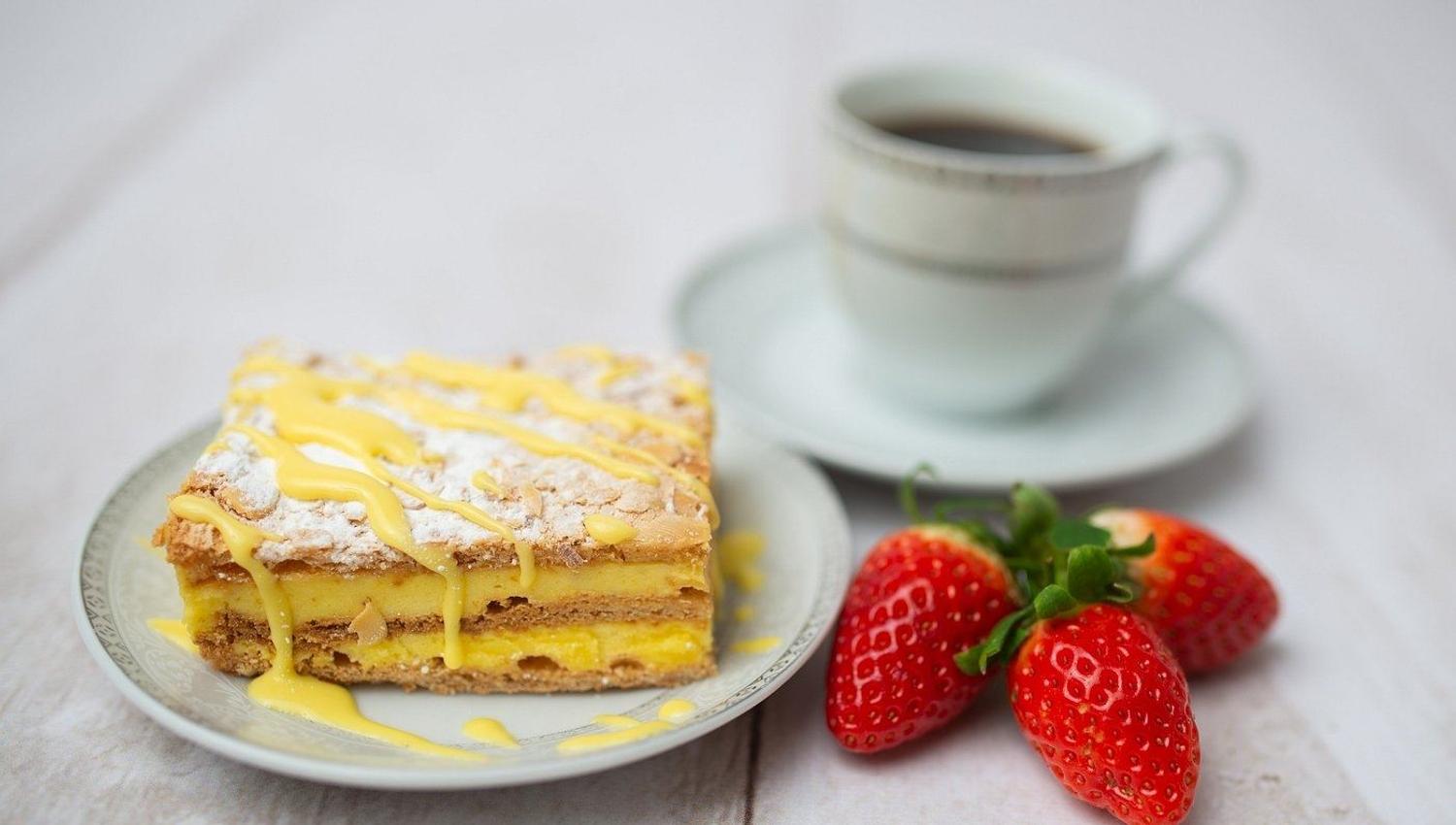 A slice of cake with strawberries and coffee served at Koseverden in Tromsø.