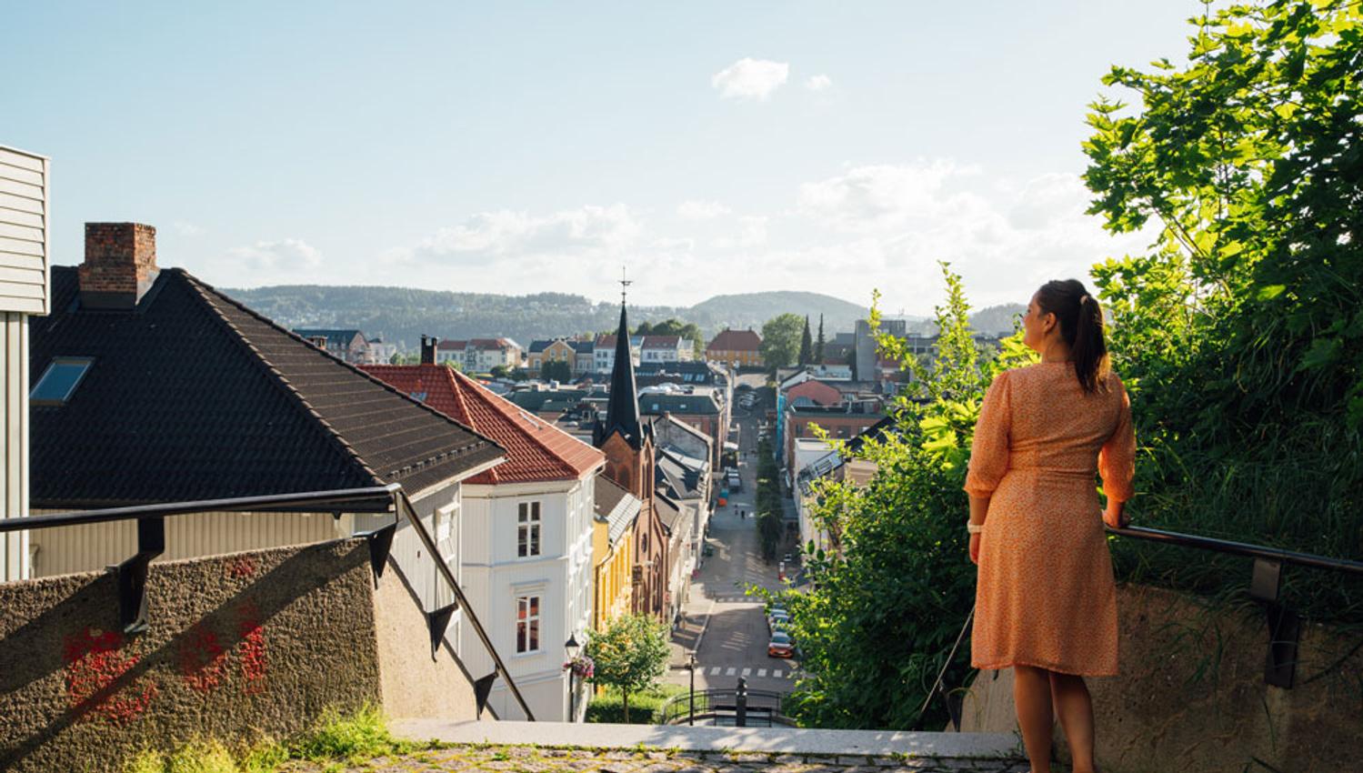 lady stands on top of Ibsentrappa in Skien and looks over the city