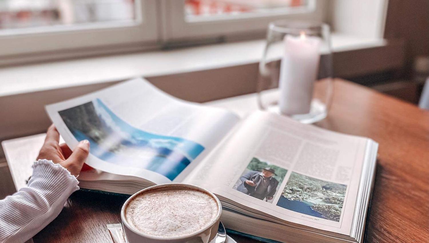 Coffee and cookies and a person looking in a book.