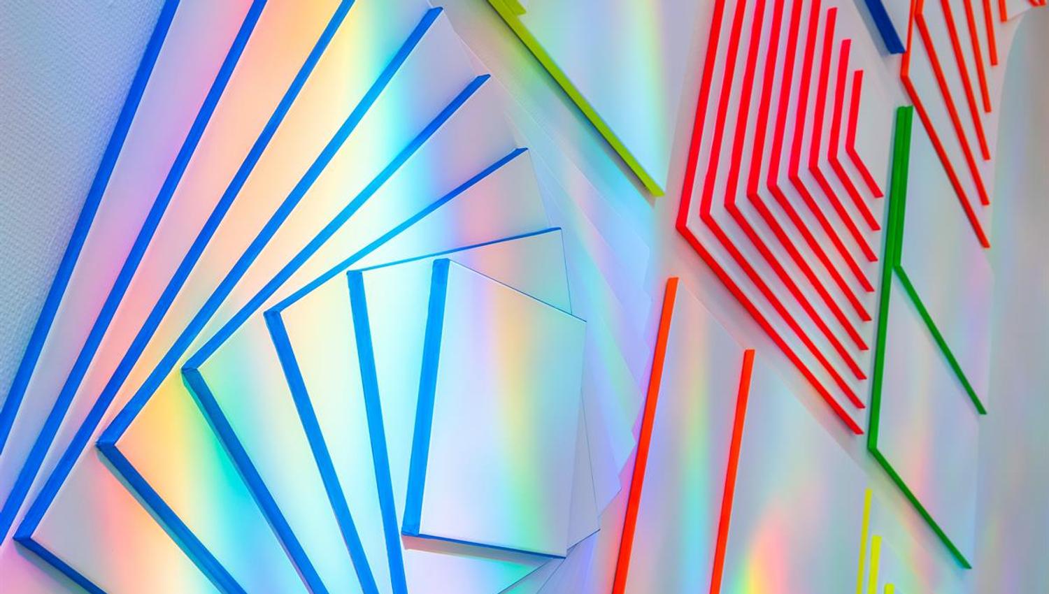 Colorful geometric art panels with light reflections.