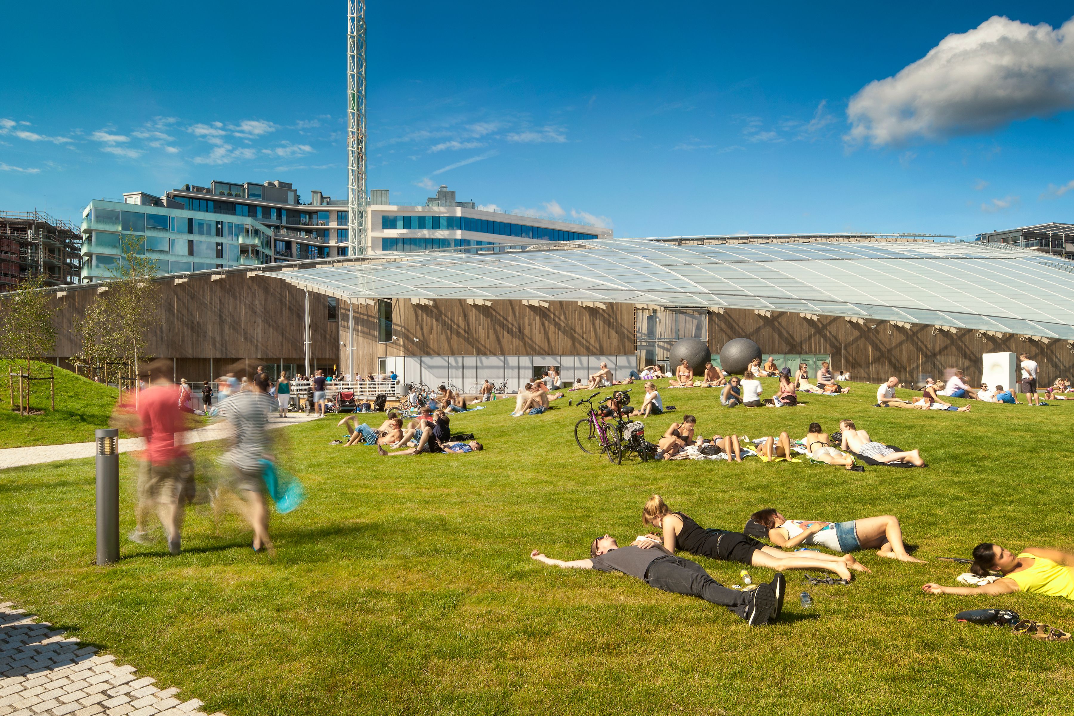 people relaxing in the grass in front of the Astrup Fearnley museum